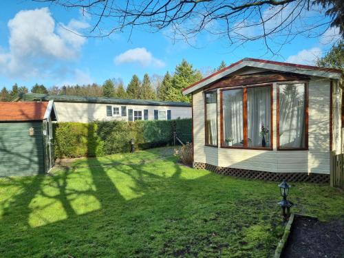 a garden view of a house with a conservatory at Camping Vossenberg - op de Veluwe! in Epe