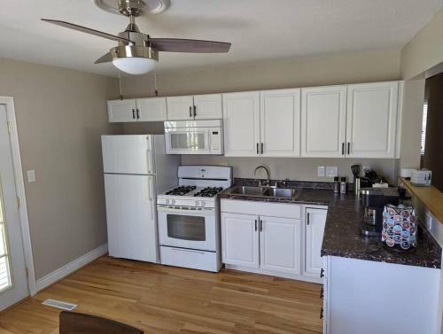una cocina con armarios blancos y electrodomésticos blancos en Comfy Champaign 3 Bedroom House, en Champaign