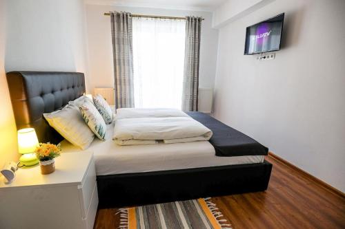 a bedroom with a bed with a desk and a window at Modern Condo with parking, Sibiu in Sibiu