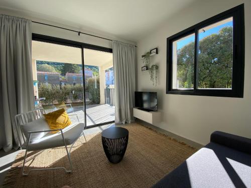 a living room with a couch and a chair and a television at STUDIO in res. LES CYCLISTES in Malaucène