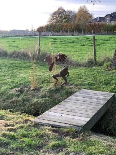 a statue of a dog jumping over a wooden bridge at L’annexe in Bastogne
