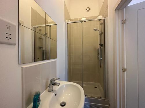 a bathroom with a sink and a shower with a mirror at 2 Bedroom Riverside Property with Roof Terrace in Stockton-on-Tees