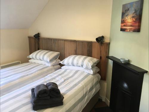 um quarto com 2 camas e almofadas brancas em Cosy Arts & Crafts Cottage with stunning views em Brecon