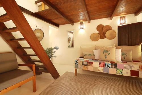 ein Schlafzimmer mit einem Bett und einer Treppe in einem Zimmer in der Unterkunft Caraiva Casa in Caraíva