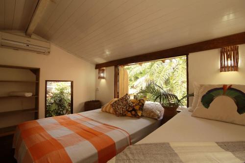 カライーバにあるCaraiva Casaのベッドルーム1室(ベッド2台、大きな窓付)