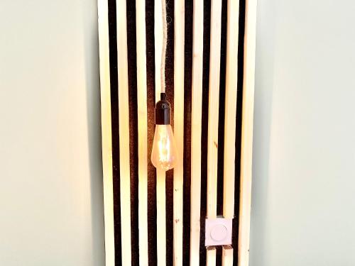 a light hanging from a wall with a fence at La Contemporaine in Brax