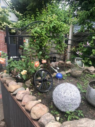 a garden with a wheelbarrow and some flowers and rocks at Monteurzimmer, Innenstadt Lage in Husum