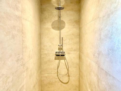 a shower with a shower head hanging from a wall at La Contemporaine in Brax