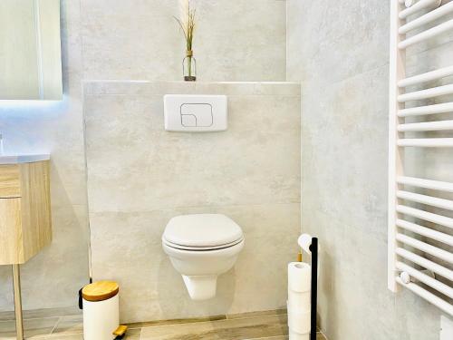 a bathroom with a white toilet in a room at La Contemporaine in Brax