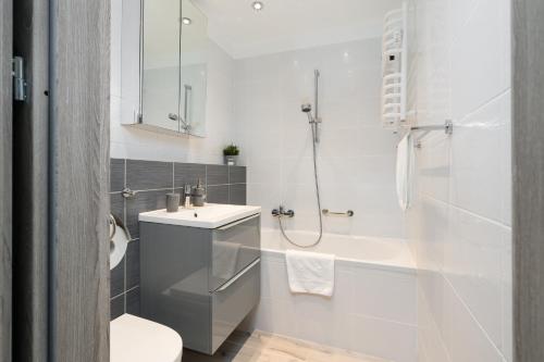 a bathroom with a toilet and a sink and a tub at Apartament Turkusowa- z widokiem na korony drzew in Poznań