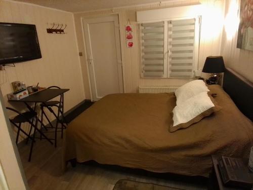 Schlafzimmer mit einem Bett, einem Tisch und einem TV in der Unterkunft Chez Marie et Daniel in Vrigne-aux-Bois