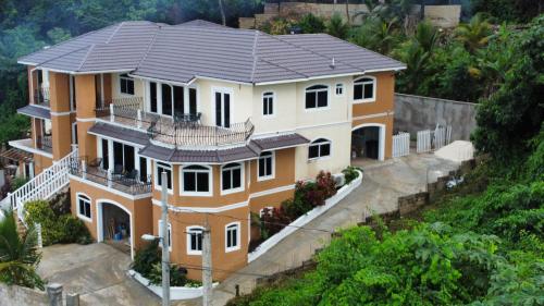 a large house with a roof on a hill at BayWatch Villa - Montego Bay in Montego Bay