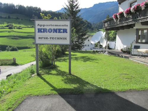 a sign in the grass in front of a house at Appartements Kroner in Nauders