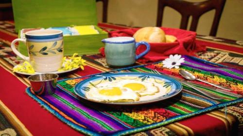 a table with a plate of eggs on a table at Beraja Family Hostel in Lima