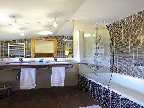 a bathroom with a tub and a sink and a shower at Evenia Monte Alba in Cerler