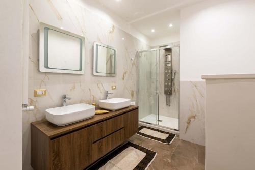 a bathroom with two sinks and a glass shower at Colosseum 10steps away, Marco Aurelio Luxury House in Rome