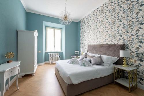 a bedroom with blue walls and a bed with white sheets at Colosseum 10steps away, Marco Aurelio Luxury House in Rome