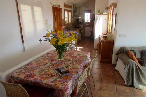 una mesa de comedor con un jarrón de flores. en Casaroc, en Sella