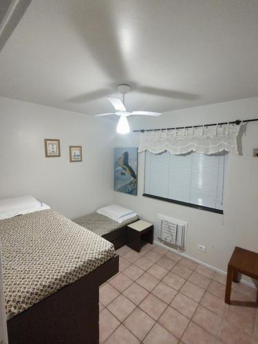 um quarto com 2 camas e uma ventoinha de tecto em Apartamento em Caioba com wi-fi em Matinhos