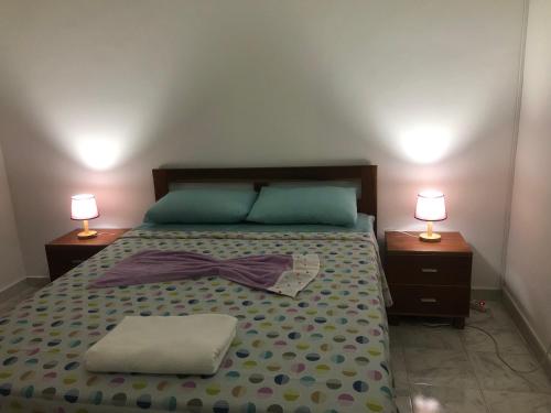 a bedroom with a bed with a bow tie on it at Apartamento T2-Dunas Centro in Tarrafal