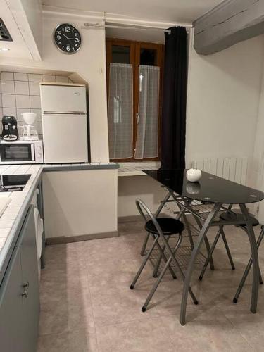 a small kitchen with a table and chairs in it at Chablis : petit studio en plein centre ville in Chablis