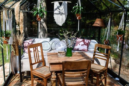 una mesa de madera y sillas en un invernadero en Willa Iga, en Karpacz