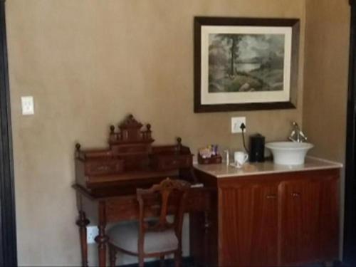 a bathroom with a wooden desk and a sink at Slot Loevenstein Guest House in Dan Pienaar