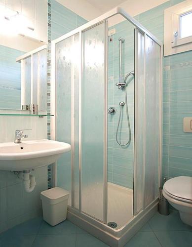 a bathroom with a shower and a sink and a toilet at Villa Boer in Bibione