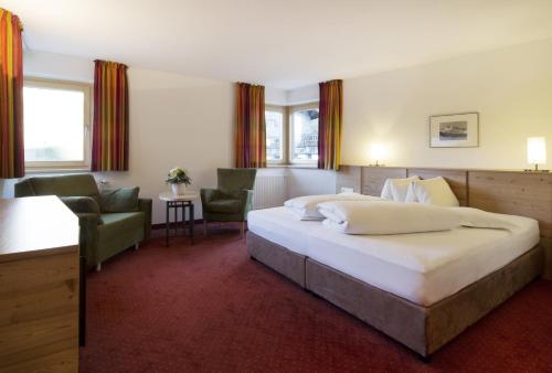 a hotel room with a bed and a chair at Schönblick - Gurgl B&B in Obergurgl