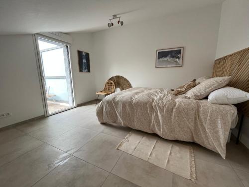 une chambre avec un lit et une grande fenêtre dans l'établissement Résidence Garden Beach Saint-cyr-sur-mer Superbe T3 neuf 100m des plages, à Saint-Cyr-sur-Mer