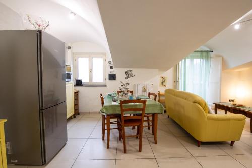 a kitchen and dining room with a table and a yellow couch at B&B delle Meraviglie Salerno Hills in Pellezzano