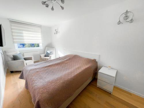 a bedroom with a bed and a chair and a window at Olympic house in Jahorina