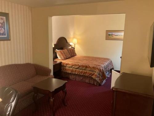 Hotel Seward في سيوارد: غرفه فندقيه بسرير واريكه