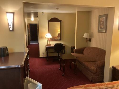 una sala de estar con sofá y escritorio en una habitación de hotel en Hotel Seward, en Seward