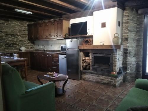 a kitchen with a stove and a fireplace at La Posada de Oscos II in Santa Eulalia de Oscos