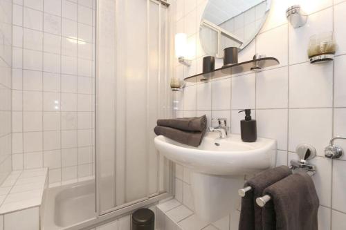 a white bathroom with a sink and a shower at Schönes Zwei-Zimmer-Apartment in der Bremer City in Bremen