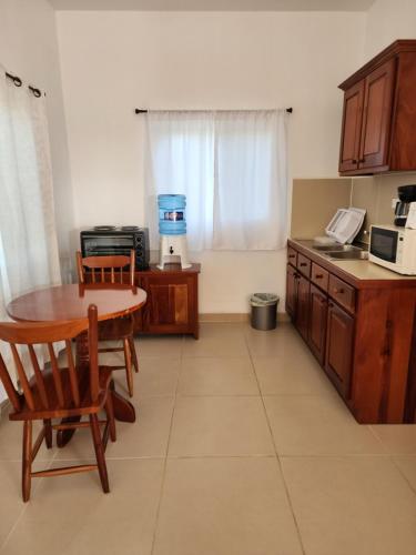 a kitchen with a table and a table and a counter at Seremei Villas in Caye Caulker