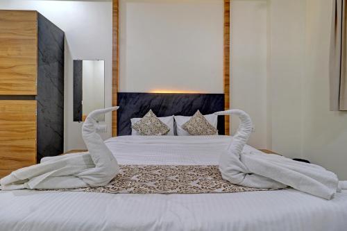 una cama con dos cisnes hechos de toallas en Ivory Suites en Airoli