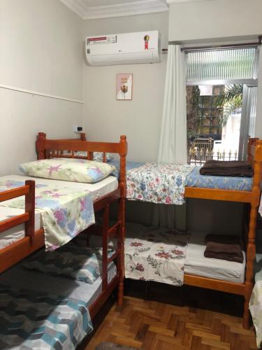 a room with three bunk beds and a window at Guest House Copacabana Hostel in Rio de Janeiro