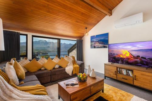 - un salon avec un canapé et un foyer extérieur dans l'établissement Distinctive Alpine Meadows, à Queenstown