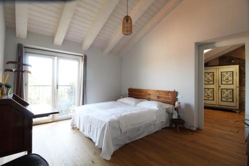 1 dormitorio con cama y ventana grande en Il Fienile di Sordevolo B&B, en Sordevolo