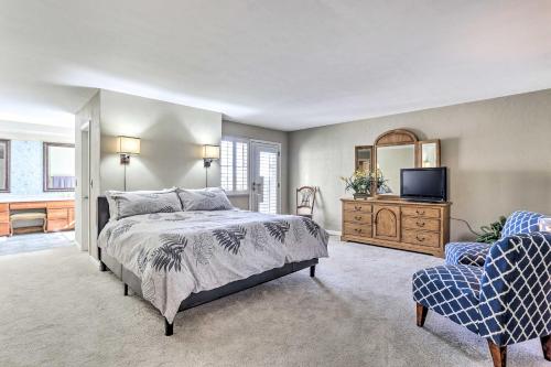 - une chambre avec un lit, une télévision et une chaise dans l'établissement Bright Centennial Home about 15 Mi to Dtwn Denver, à Centennial