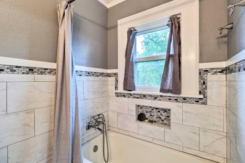 a bathroom with a tub and a window at 1920s Corsicana Home - Spacious Group Getaway! in Corsicana