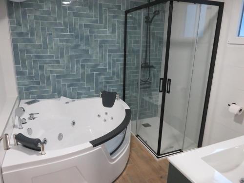 y baño con bañera y ducha. en Belice, excepcional apartamento con Jacuzzi, en Punta Umbría