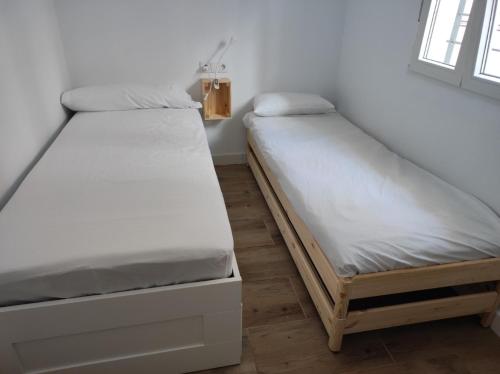 dwa łóżka siedzące obok siebie w pokoju w obiekcie Belice, excepcional apartamento con Jacuzzi w mieście Punta Umbría
