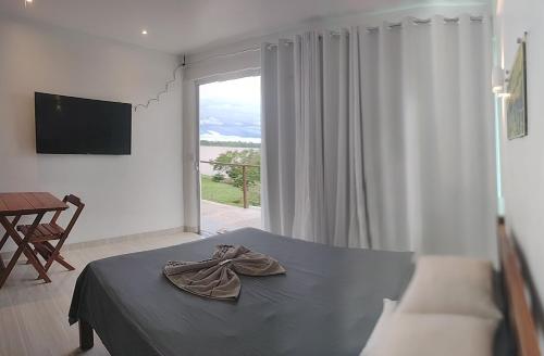 a bedroom with a bed and a large window at Casa do Francês na Praia in Boa Vista