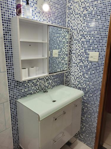 een badkamer met een wastafel en een spiegel bij Casa de praia Jequitiba, 50 metros do mar com piscina!!ITANHAÉM! in Itanhaém