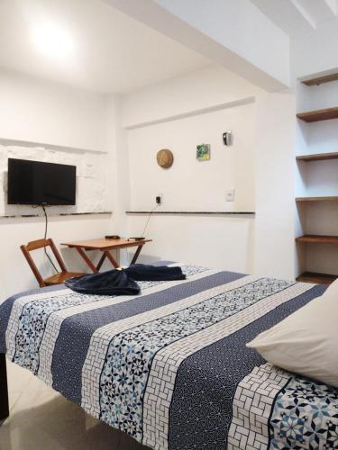 a bedroom with a bed and a table and a tv at hotel Casa do Francês na Praia in Boa Vista