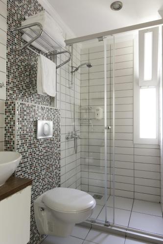 a bathroom with a toilet and a glass shower at Hideaway in Kas