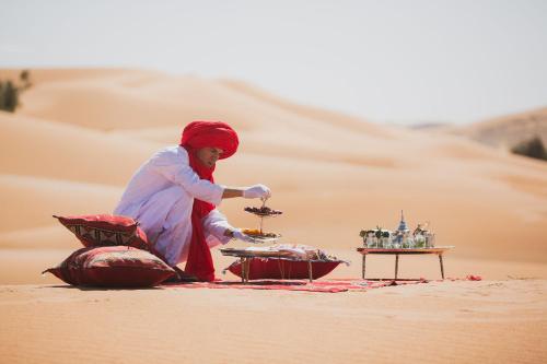een vrouw in de woestijn die voedsel kookt in de woestijn bij camp erg chebbi luxury in Merzouga